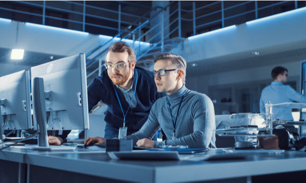 Developer teaching his colleague in programming
