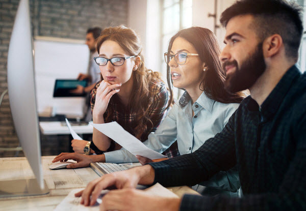 Team checking a work on a monitor